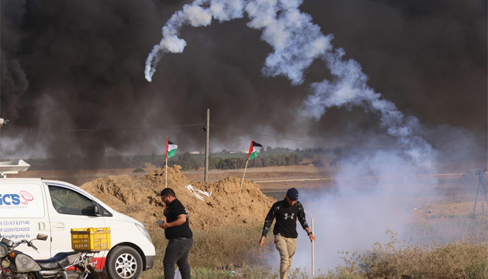 Protesters evade tear gas canisters fired by Israeli forces during a protest by the border fence with Israel east of Khan Yunis, in the southern Gaza Strip, on July 4, 2023. — AFP