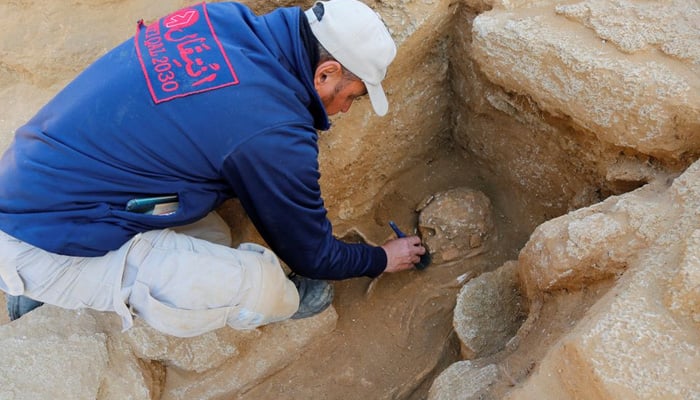 An archaeology expert works on remains found in a grave at the site of a 2000-year-old Roman cemetery, that had been discovered last year, in the northern Gaza Strip on February 14, 2023. — Reuters