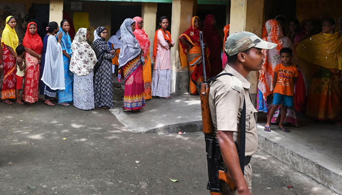 A police officer stands guard as people queue at a polling station to cast their vote in West Bengal’s ‘Panchayat’ or local elections, on the outskirts of Kolkata on July 8, 2023. — AFP