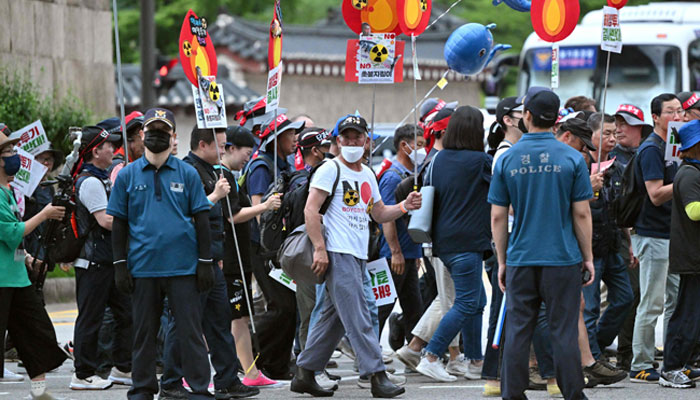 South Korean protesters march during a rally against Japans plan to discharge treated water from the Fukushima nuclear plant, on a road near the Japanese embassy in Seoul on July 8, 2023. — AFP