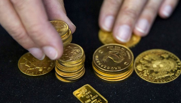 A worker places gold bullion on display at Hatton Garden Metals precious metal dealers in London, Britain July 21, 2015. — Reuters