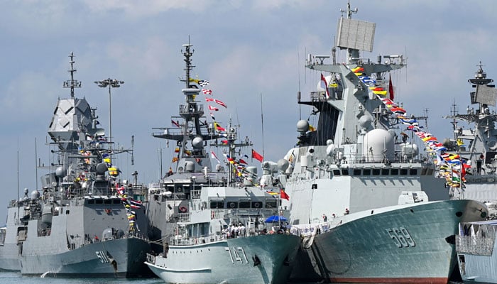 Chinese Navy missile frigate Yulin (right) and the minesweeper hunter Chibi (centre) are seen docked at Changi Naval Base during the IMDEX Asia warships display in Singapore on May 4, 2023. — AFP