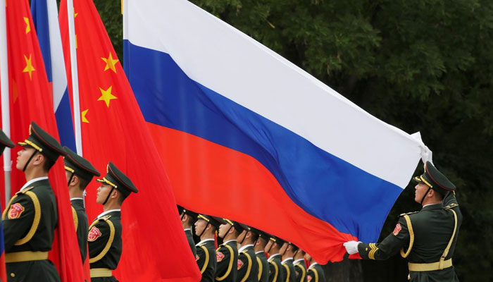 A military officer adjusts a Russian flag ahead of a welcome ceremony hosted by Chinese President Xi Jinping for Russian President Vladimir Putin outside the Great Hall of the People in Beijing, China June 8, 2018. — Reuters