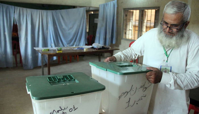 A staffer of the provincial Election Commission of Pakistan finalises arrangements at polling station in Karachis Bihar Colony on May 6, 2023. — Online