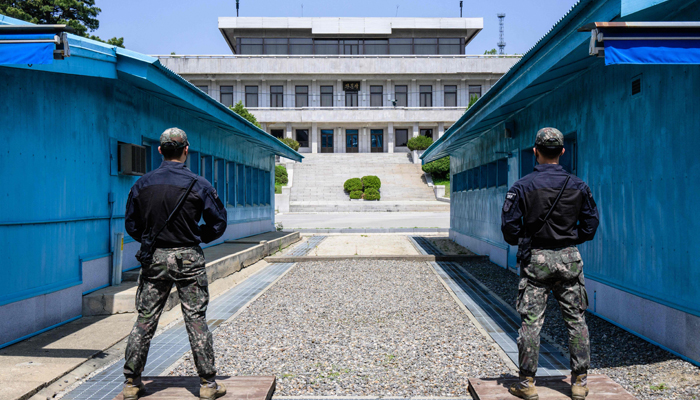 In this photo taken on May 9, 2023, South Korean soldiers stand guard as they face North Koreas Panmon Hall (back) at the truce village of Panmunjom in the Joint Security Area (JSA) of the Demilitarised Zone (DMZ). — AFP