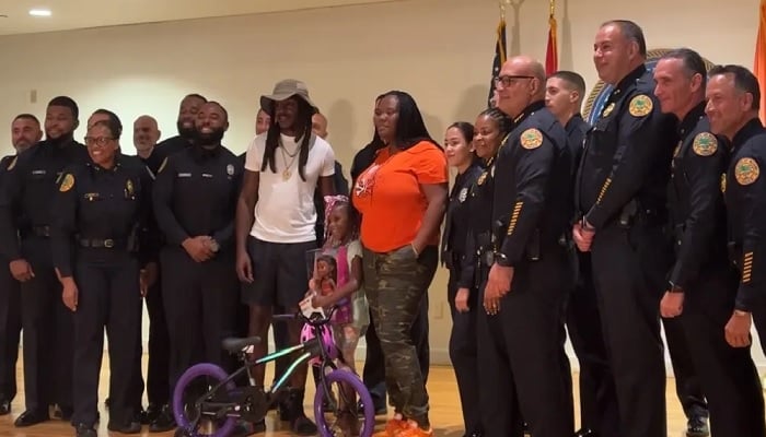 Lyric, her parents, and Miami Police Department officers pose for a photo. — Miami PD