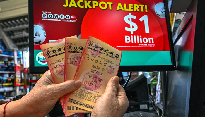 A woman holds Powerball lottery tickets inside a store in Homestead, Florida on July 19, 2023. — AFP