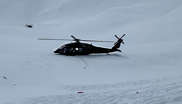 Two rescue helicopters are seen near the wreckage (not shown) of another helicopter that crashed near the Knik Glacier, northeast of Anchorage, Alaska, US March 28, 2021. — Facebook/Alaska Mountain Rescue Group