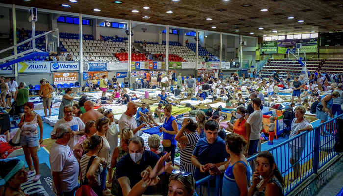 Tourists gesture in a basketball hall where they spent their night due to the wildfire in Rhodes, on the Greek island of Rhodes on July 23, 2023. — AFP