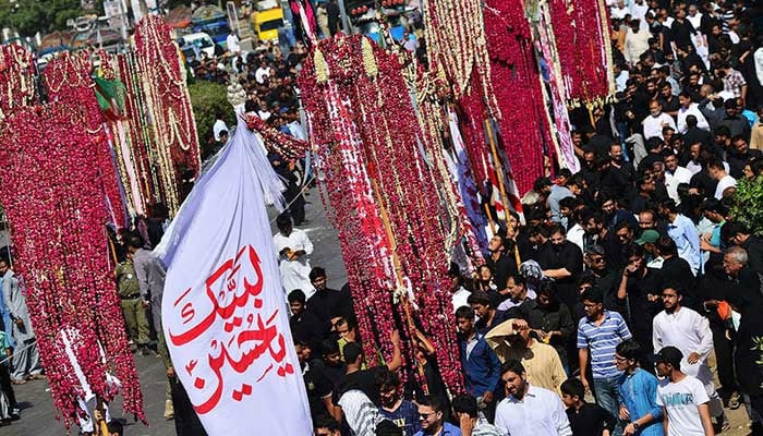 Mourners hold religious flags as they march in a procession on Muharram 8 in Karachi. — AFP/File