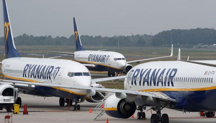A Ryanair airplane taxis past two parked aircraft at Weeze Airport, near the German-Dutch border on September 12, 2018. —Reuters