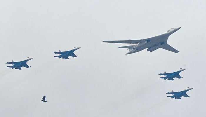 Russian Tupolev Tu-160 strategic bomber and Su-35S jet fighters fly in formation over central Moscow during the Victory Day military parade on May 9, 2021. — AFP