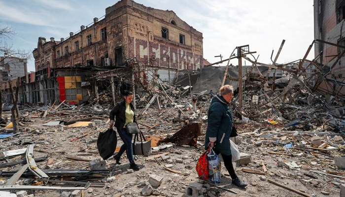 Residents carry their belongings near buildings destroyed in the course of the Ukraine-Russia conflict, in the southern port city of Mariupol, Ukraine April 10, 2022. — Reuters