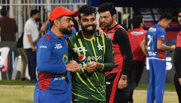 Shadab Khan and Afghanistans Rashid Khan interact during the opening T20 International in Sharjah on March 24, 2023. — Twitter/@ACBofficials