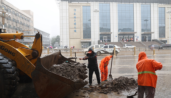 Rescue officials can be seen removing mud from a road in Beijing after torrential rain in the Chinese capital city, in this picture on August 1, 2023. — Twitter/@CTGN