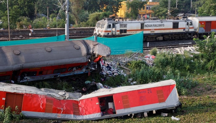 A train moves past damaged coaches after tracks were restored at the site of a train collision in the eastern state of Odisha, India, June 5, 2023. — Reuters