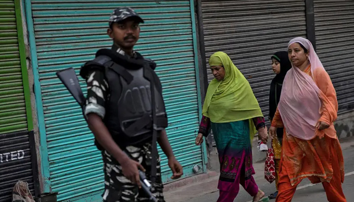 Kashmiris walk past Indian security personnel during restrictions after the scrapping of the special constitutional status for Kashmir, in Srinagar, August 11, 2019. — Reuters