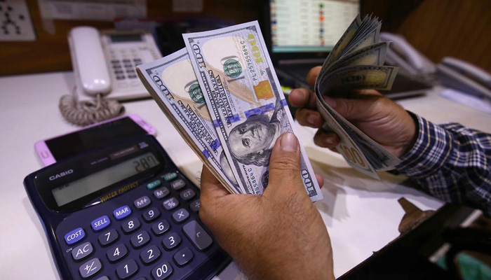 A man counts US dollar after its rate in Pakistan climbs Rs279.5 on March 2, 2023. — INP