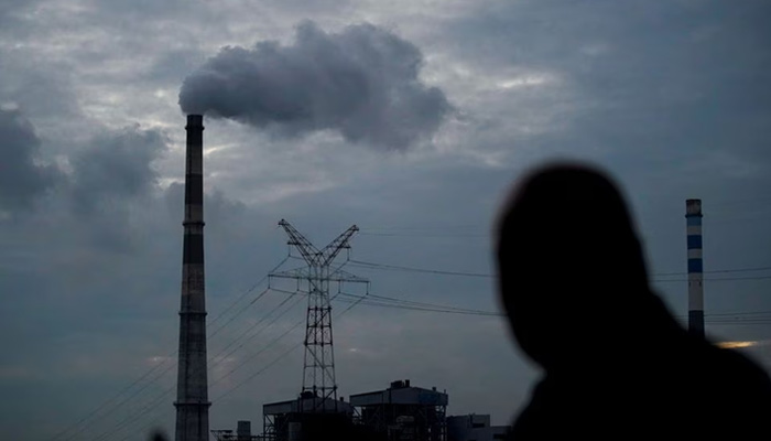 A man walks past a coal-fired power plant in Shanghai, China, October 14, 2021. — Reuters