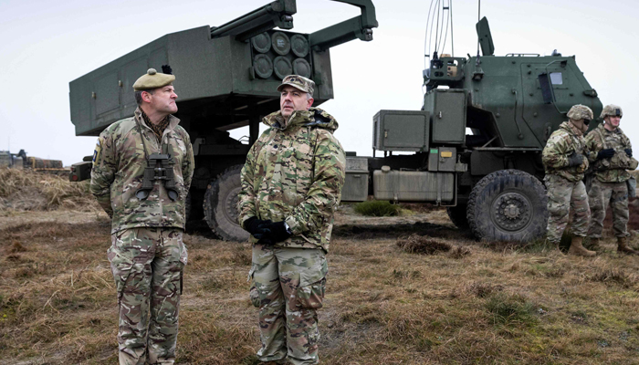 Servicemen stand in front of the HIMARS M142 High Mobility Artillery Rocket System during the Dynamic Front military exercise led by the United States in Oksbol, Denmark on March 30, 2023. — AFP