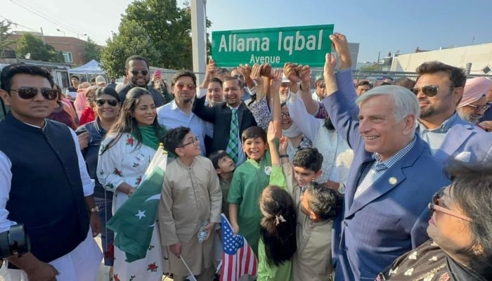 People hold up the sign Allama Iqbal Avenue in Queens, New York. — Pakistani Embassy in Washington