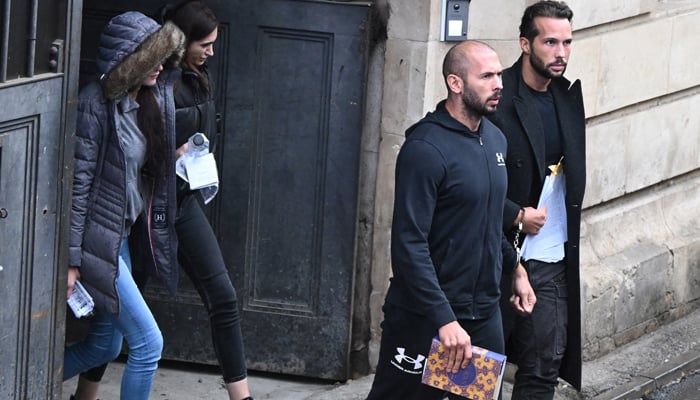 British-US former professional kickboxer and controversial influencer Andrew Tate (3rd L) and Tristan Tate (R) together exit a court in Bucharest, Romania, on January 10, 2023. — AFP