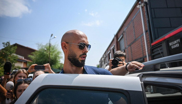 Controversial influencer Andrew Tate leaves by car after addressing the media in front of his home in Bucharest, August 4, 2023. — AFP