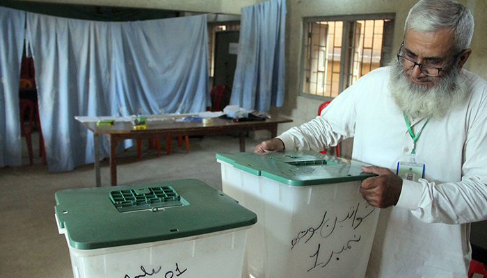 A worker of the Election Commission of Pakistan finalising the arrangements at polling in Karachi, on May 6, 2023. — Online