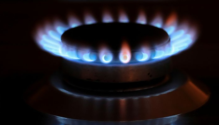 Flames from a gas burner are reflected on a cooker in a private home. — Reuters