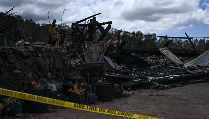Police tape surrounds the site of a home destroyed by the Maui wildfires in Kula, Hawaii on August 13, 2023. — AFP