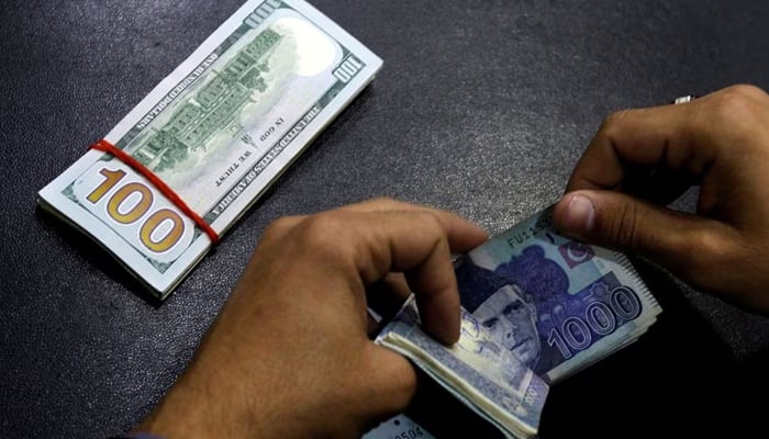 A currency trader counts Pakistani Rupee notes as he prepares an exchange of U.S dollars in Islamabad, Pakistan December 11, 2017. — Reuters.