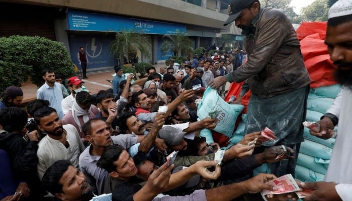 Men reach out to buy subsidised flour sacks from a truck in Karachi, Pakistan January 10, 2023. — Reuters