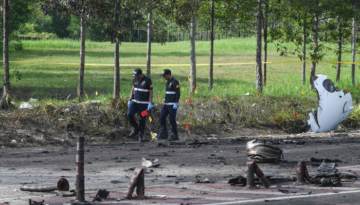 Members of the fire and rescue department inspect the crash site of a plane in Shah Alam, Malaysia´s Selangor state on August 17, 2023. — AFP