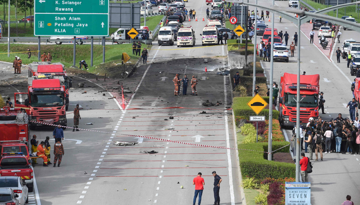 Members of the fire and rescue department inspect the crash site of a plane on a street in Shah Alam, Malaysias Selangor state on August 17, 2023. — AFP