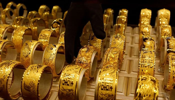 A salesperson arranges 24K gold bracelets for Chinese weddings at Chow Tai Fook Jewellery store in Hong Kong, China December 14, 2017. — Reuters