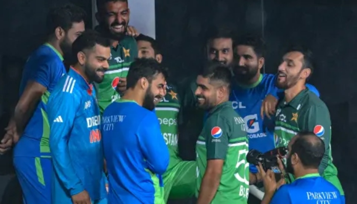 Pakistan and Indian side players share a light moment after the rain played spoilsport during their group stage clash on September 2, 2023. — AFP