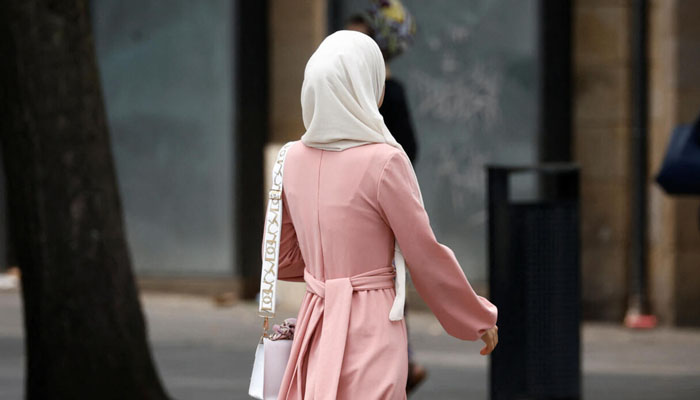 A Muslim woman, wearing the style of dress called an abaya, walks in a street in Nantes, France, August 29, 2023. — Reuters