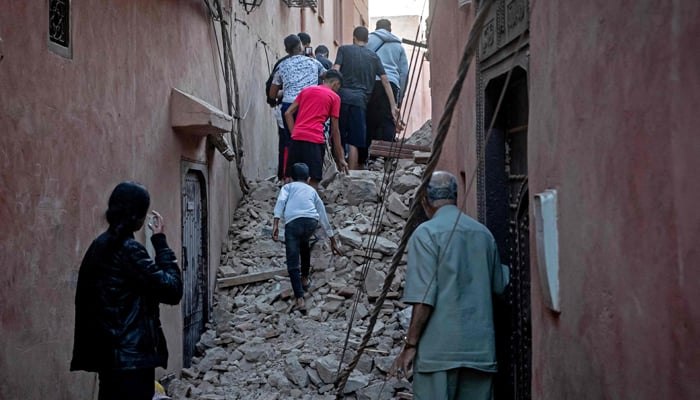 Residents evacuate through the rubble in the earthquake-damaged old city of Marrakesh on September 9, 2023. — AFP