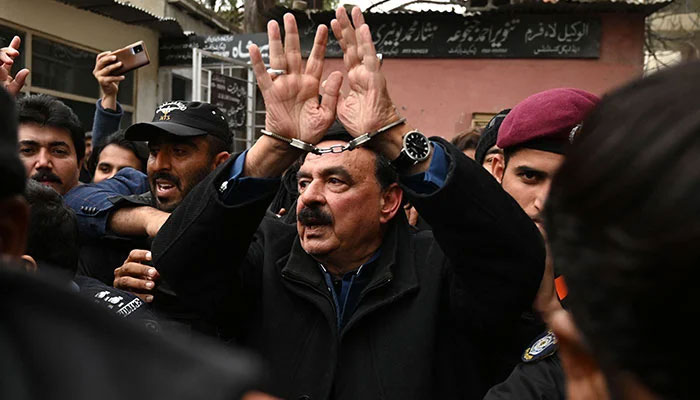 Police officials escort former interior minister Sheikh Rashid Ahmed (centre) to present him before a court in Islamabad on February 2, 2023. — AFP