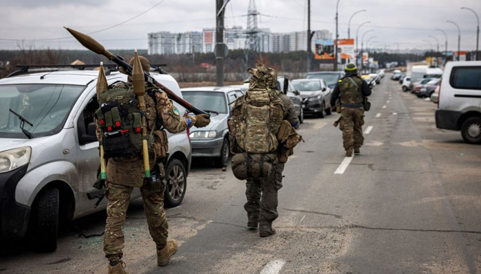 Kyivs servicemen can be seen walking in a war-torn area amid the Russia-Ukraine war. AFP/File