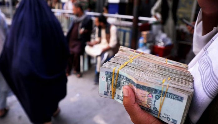 A person holds a bundle of Afghan afghani banknotes at a money exchange market, following banks and markets reopening after the Taliban took over in Kabul, Afghanistan, September 4, 2021. — Reuters