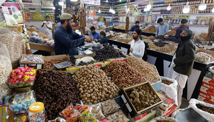 People buy dry fruits at a market in Karachi, on February 1, 2023. — Reuters