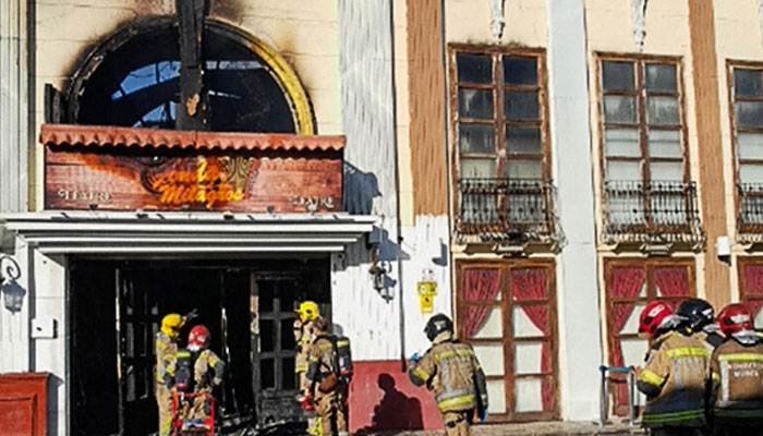 This handout photograph taken and released on October 1, 2023 by the 112 Emergency Services of the Murcia Region shows firefighters entering the Teatre nightclub as at least thirteen people were killed in a fire, in Murcia.—AFP