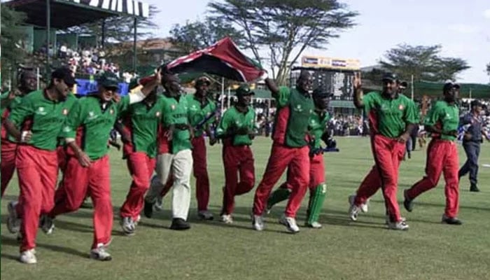 Para pemain Kenya berlari melintasi lapangan sambil memegang bendera nasional setelah mengalahkan Sri Lanka dan mengejutkan dunia kriket.  — Reuters/Berkas