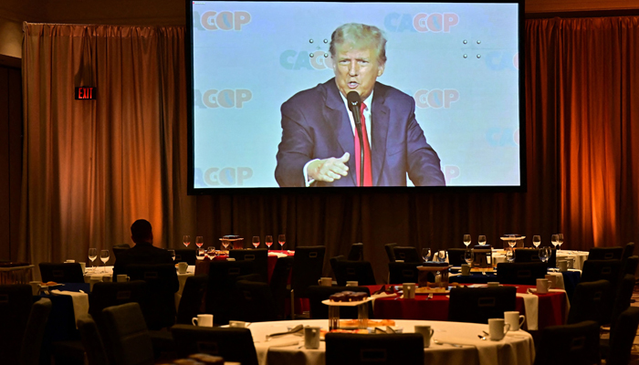 Former US president Donald Trump delivers his speech as seen on a screen in the spillover room at the Anaheim Mariott on September 29, 2023. — AFP