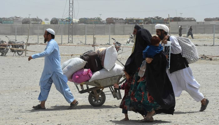 People walk towards a border crossing point in Pakistans border town of Chaman on July 17, 2021. — AFP