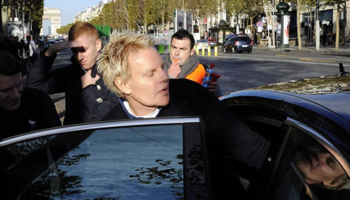 Mike Jeffries, ex-CEO of clothing retailer Abercrombie & Fitch, leaves the store on the Champs Elysees avenue in Paris on October 27, 2012.—AFP