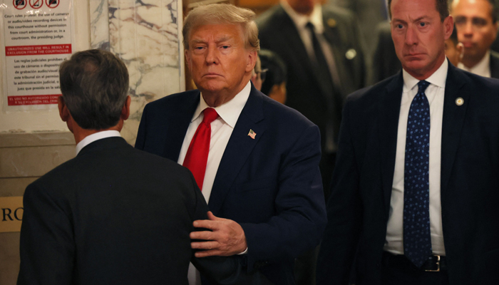 Former President Donald Trump leaves the courtroom for a lunch recess during the second day of his civil fraud trial at New York State Supreme Court on October 03, 2023, in New York City. — AFP