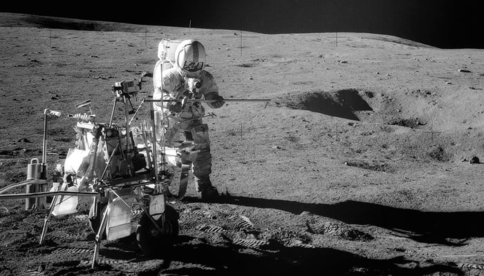 Apollo 14 Astronaut Alan B Shepard Jr. assembles equipment on the lunar surface in February 1971. — Nasa