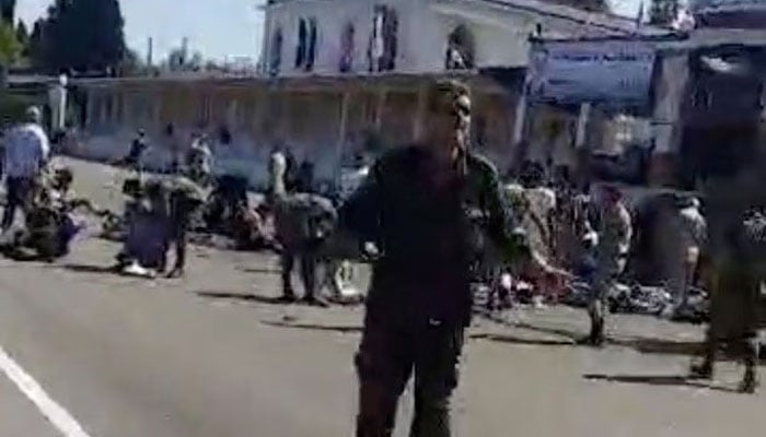 People stand and walk outside a building after drone attack on Syrian military academy in Homs, Syria October 5, 2023 is seen in this screen grab from a video. — Reuters/Screengrab